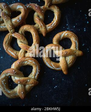 Nahaufnahme von hausgemachten weichen Brezeln auf schwarzem Hintergrund. Stockfoto