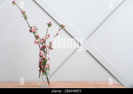 Vase mit schönen blühenden Zweigen auf dem Tisch Stockfoto