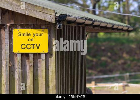 Lächeln Sie mit einem CCTV-Warnschild Stockfoto