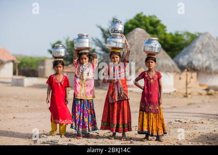 Indien, Gujarat Staat, Kutch Region, Ludiya Dorf, nahe Bhuj, Gruppe von Meghwal Mädchen, die Töpfe des Trinkwassers auf ihrem Kopf tragen Stockfoto