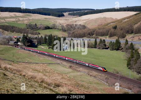 Virgin Trains Alstom Pendolino Zug fährt die Harthorpe Bank entlang der schottischen Westküste Hauptlinie durch die Landschaft des Clyde-Tal Stockfoto