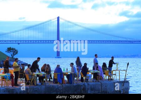 Portugal, Lissabon, Almada, traditionelles portugiesisches Restaurant Ponto Final am Tejo mit Ponte 25 de Abril im Hintergrund Stockfoto