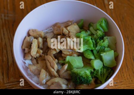 Gekochtes Teriyaki-Huhn, gedünsteter Reis und Brokkoli in einer rosa Schüssel. Stockfoto