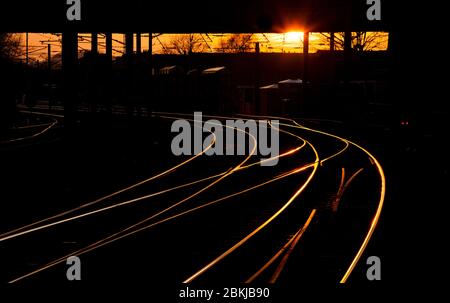 Sonnenuntergang auf der Bahnlinie mit den Kreuzungspunkten am westlichen Ende der Skipton Station Stockfoto