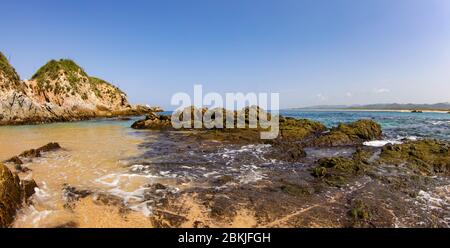 Die wunderschönen Felsformationen am Mayto Beach in Jalisco, Mexiko. Bedeckt mit klarem Meerwasser. Strahlend blauer Himmel ohne Wolken. Stockfoto