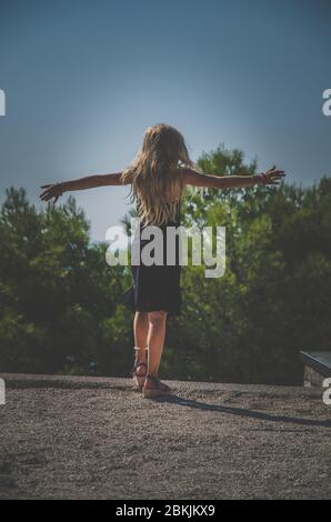 Nettes Kind in schwarzem Kleid tanzen im Sommer Tag gekleidet Stockfoto