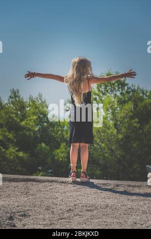 Nettes Kind in schwarzem Kleid tanzen im Sommer Tag gekleidet Stockfoto