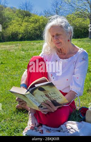 Europa, Luxemburg, Insenborn, attraktive ältere Frau sitzend Lesung von Lac Sûre Stockfoto