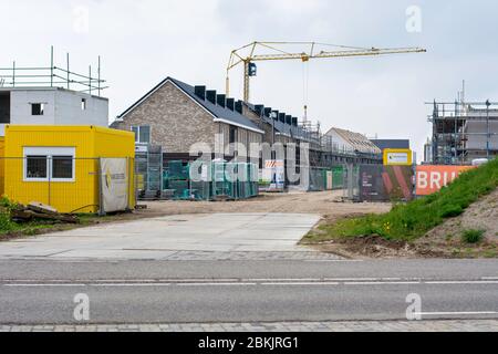 Wohnhäuser werden auf einer Baustelle gebaut. Neue Nachbarschaft in Zwolle, Niederlande. Modernes nachhaltiges Wohnen mit Bauwerkzeugen Stockfoto