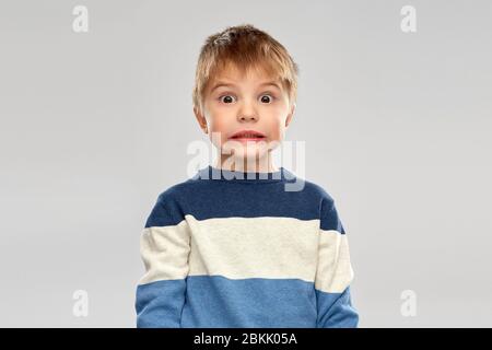 Schockiert kleiner Junge im gestreiften Pullover Stockfoto