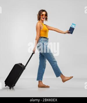 Glückliche junge Frau mit Flugticket und Reisetasche Stockfoto