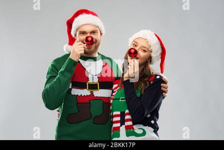 Glückliches Paar in Weihnachten Pullover und Santa Hüte Stockfoto