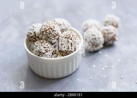 Gesunde rohe Energiebälle mit Kakao, Kokosnuss, Sesam, Chia auf weißem Hintergrund. Gesunde hausgemachte Paleo Schokolade Energiebällchen mit Haferflocken, Nüssen, Stockfoto