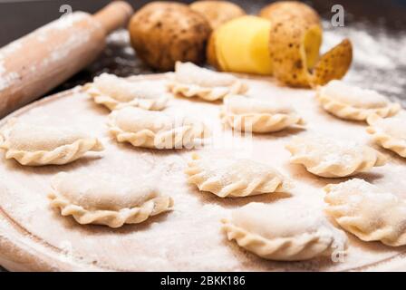 Hausgemachte rohe Knödel mit Füllung auf einem Holzbrett Stockfoto