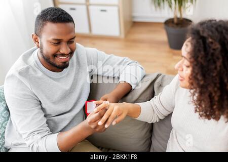 afroamerikanischer Mann, der Frau Verlobungsring gibt Stockfoto