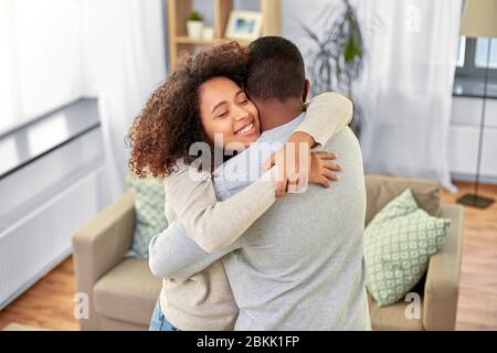 Glückliches afroamerikanisches Paar, das zu Hause umarmt Stockfoto