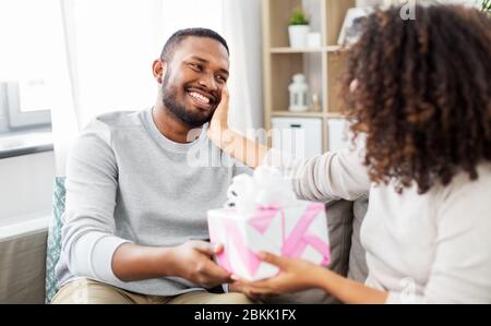 Glückliches Paar mit Geschenk zu Hause Stockfoto