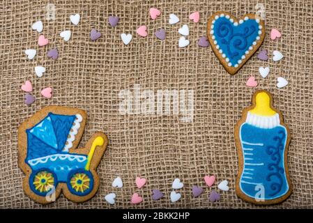 Kekse auf einem Burlap in Form eines Kinderwagens in einer Flasche Babyherzen. Baby-Duschkeks auf dem Tisch Stockfoto