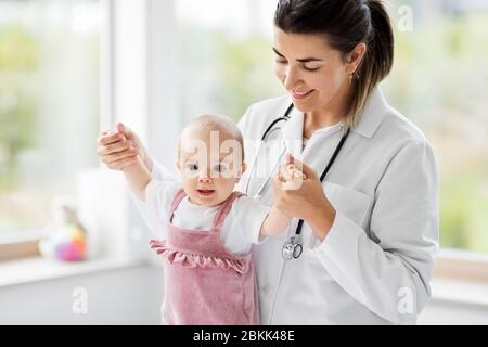 Weibliche Kinderarzt Arzt mit Baby in der Klinik Stockfoto