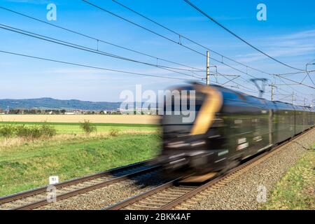 Ein Elektrozug fährt auf Bahngleisen durch eine wunderschöne Landschaft Stockfoto