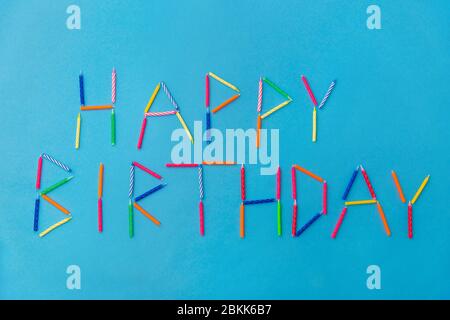 Worte Happy Birthday aus Kerzen auf blau Stockfoto