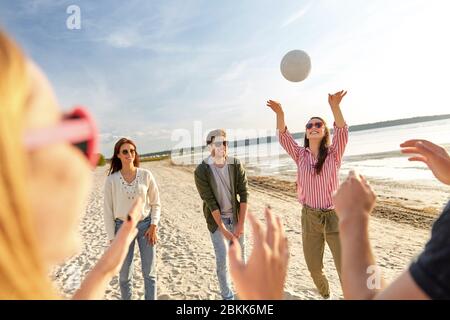 Freunde spielen Volleyball am Strand im Sommer Stockfoto