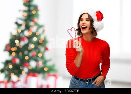 Glückliche junge Frau in weihnachtsmütze zu weihnachten Stockfoto