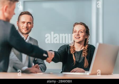 Junge Kollegen, die sich in der Gruppe die Hände schütteln, treffen aufeinander Stockfoto