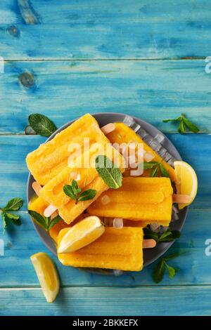 Vertikale Aufnahme von gelb erfrischenden Eis Sorbet auf blau rustikalen Hintergrund Stockfoto