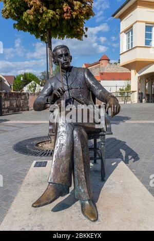 Eger, Ungarn - 04 26 2020: Statue von Geza Gardonyi in Eger, Ungarn mit der Burg im Hintergrund an einem Frühlingsnachmittag. Stockfoto