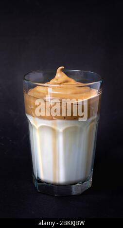 Vertikales Dalgona-Kaffeeglas, aufgeschlagenen kalten Kaffee mit Milch Stockfoto