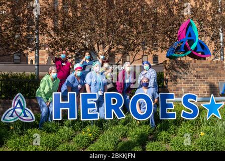Detroit, Michigan, USA. Mai 2020. Die Mitarbeiter des Gesundheitswesens posieren von einem Heldenwerk hier, nachdem Ersthelfer am Ascension St. John Hospital vorbeimarschierten, um die Krankenhausmitarbeiter für ihre Arbeit während der Coronavirus-Pandemie zu ehren. Kredit: Jim West/Alamy Live News Stockfoto
