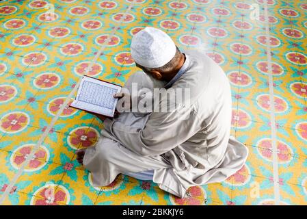 Ein Imam wird gesehen, während er den heiligen Koran während des heiligen Monats Ramadan in der Moschee liest. Ramadan ist der ganzheitliche Monat des islamischen Kalenders, in dem Gläubige von Sonnenaufgang bis Sonnenuntergang fasten. Muslime auf der ganzen Welt feiern den Monat Ramadan und haben verschiedene Wege gefunden, diesen Monat Ramadan zu feiern, da die Beschränkungen, die von Ländern zur Eindämmung der Verbreitung des Coronavirus auferlegt wurden, Moscheen geschlossen haben, um Versammlungen zu verhindern. Stockfoto