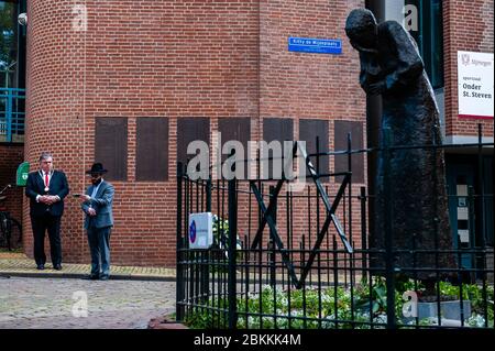 Rabbi M. Levin und der Bürgermeister von Nijmegen Hubert Bruls werden gesehen, wie sie sich auf den Beginn der Zeremonie vorbereiten.die gedenkfeiern fanden in der "Kitty de Wijze" statt, einem Denkmal, das zum Symbol der Juden in Nijmegen geworden ist, die deportiert wurden und nie wieder kommen. In diesem Jahr wurde die Zeremonie aufgrund der aktuellen Situation ohne Zuhörerschaft abgehalten, nur in Anwesenheit von Rabbi M. Levin und Bürgermeister von Nijmegen Hubert Pinselwood ist auch Vorsitzender des Sicherheitsrates des Landes. Der Gedenkgottesdienst in der Sint Stevens Kirche wurde in diesem Jahr abgesagt. Stockfoto