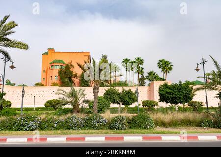 Großer Boulevard mit grünen Pflanzen und Palmen mit der Stadtmauer in Marrakesch Marokko Stockfoto