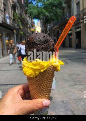Frau Hand hält schmelzende Schokolade und Obst Eis Waffel-Kegel, Street Life Stockfoto