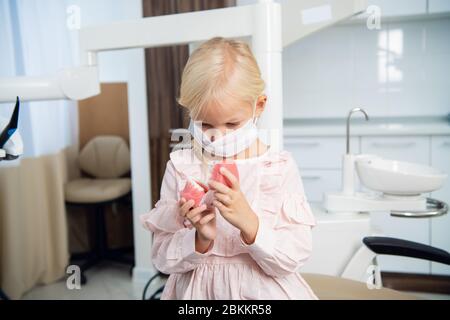 Ein Kind, das die Kieferstruktur des Menschen im Zahnarztpraxis erlernt. Stockfoto