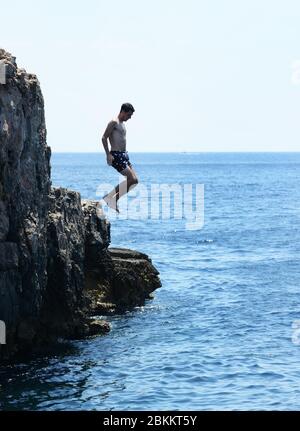 Springen ins Meer von den Küstenklippen der Insel Lokrum in der Nähe von Dubrovnik, Kroatien. Stockfoto