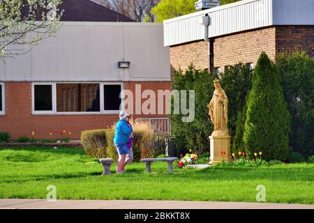 Streamwood, Illinois, USA. Zwei Frauen beenden das Gebet an einem Schrein in einem Kirchhof als Alternative zu den in-Kirche Gottesdiensten. Stockfoto
