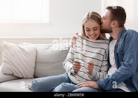 Junges Paar glücklich über positive Ergebnisse der Schwangerschaftstest Stockfoto