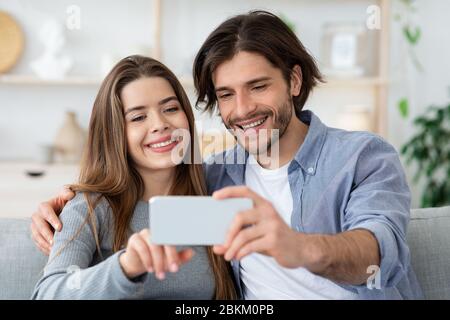 Positive Paar in Liebe, die Selfies zu Hause Stockfoto