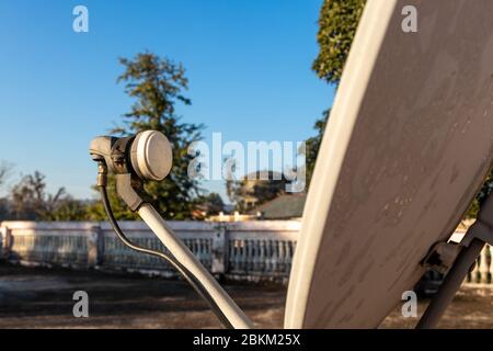 LNB, Satellitenschüssel über dem blauen Himmel im Hintergrund, selektiver Fokus. Stockfoto