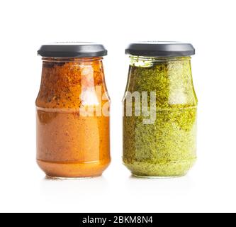 Grünes Basilikum und rotes Tomatenpesto Dip-Sauce im Glas auf weißem Hintergrund isoliert. Stockfoto