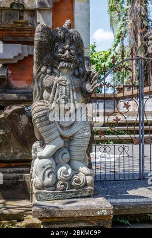 Steinstatue von Rangda am Eingang des balinesischen Hindu Pura Dalem (Tempel der Toten), Gianyar, Bali, Indonesien. Vertikales Bild. Stockfoto