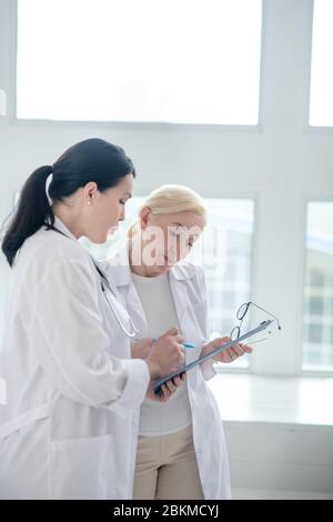 Zwei Doktoren stehen am Fenster und sehen beschäftigt aus Stockfoto