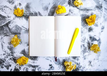 Leeres Notizbuch mit gelbem Stift und zerknittert gelben Papieren, Geschäftsplanung und Brainstorming. Entstehungsprozess und Autorenkonzept Stockfoto