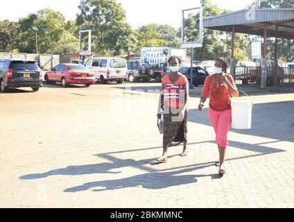 Harare, Simbabwe. Mai 2020. Zwei Fußgänger mit Gesichtsmasken gehen auf einer Straße in Harare, Simbabwe, 4. Mai 2020. Der simbabwische Präsident Emmerson Mnangagwa verlängerte am 1. Mai eine Lockdown, um die Ausbreitung von COVID-19 um zwei weitere Wochen bis zum 17. Mai zu drosseln. Die Polizei in Simbabwe wird ab Montag jeden verhaften, der seine Wohnung verlässt, ohne Gesichtsmasken zu tragen. Kredit: Shaun Jusa/Xinhua/Alamy Live News Stockfoto