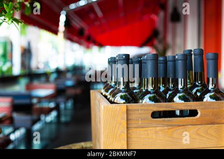 Eine Holzkiste mit Weinflaschen gefüllt. Bankfeier in einem Open-Air-Restaurant. Stockfoto