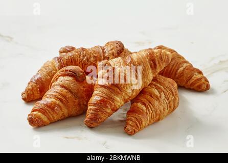 Frisch gebackene Croissants auf einem hellen Küchentisch Stockfoto