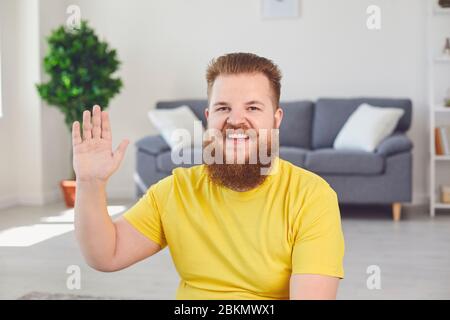 Online-Konferenz-Videokonferenz-Chat. Lustiger bärtiger Mann lächelnd schaut auf die Kamera im Zimmer im Home Office. Stockfoto